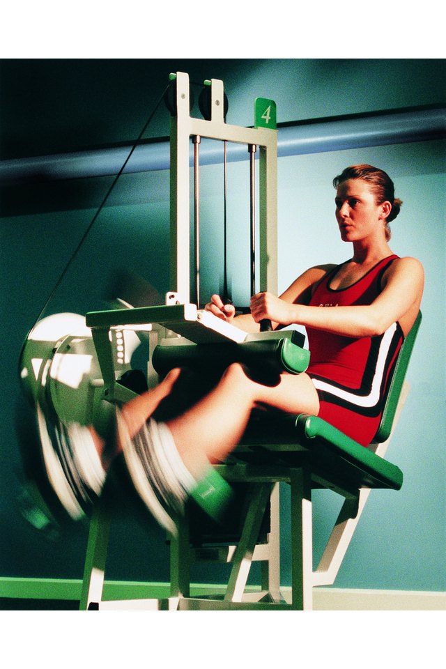 Woman performing hamstring curls on weight machine