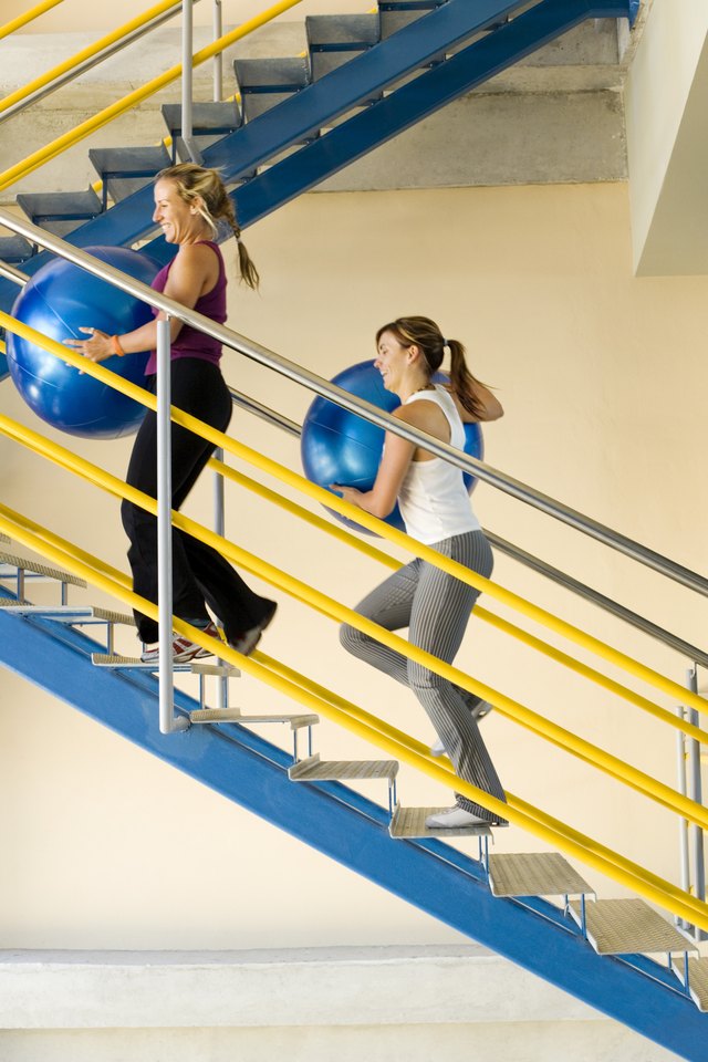 Women walking up stairs with exercise balls