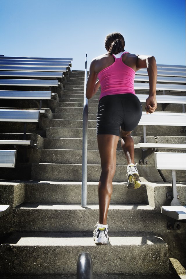 Athletic woman running up bleachers