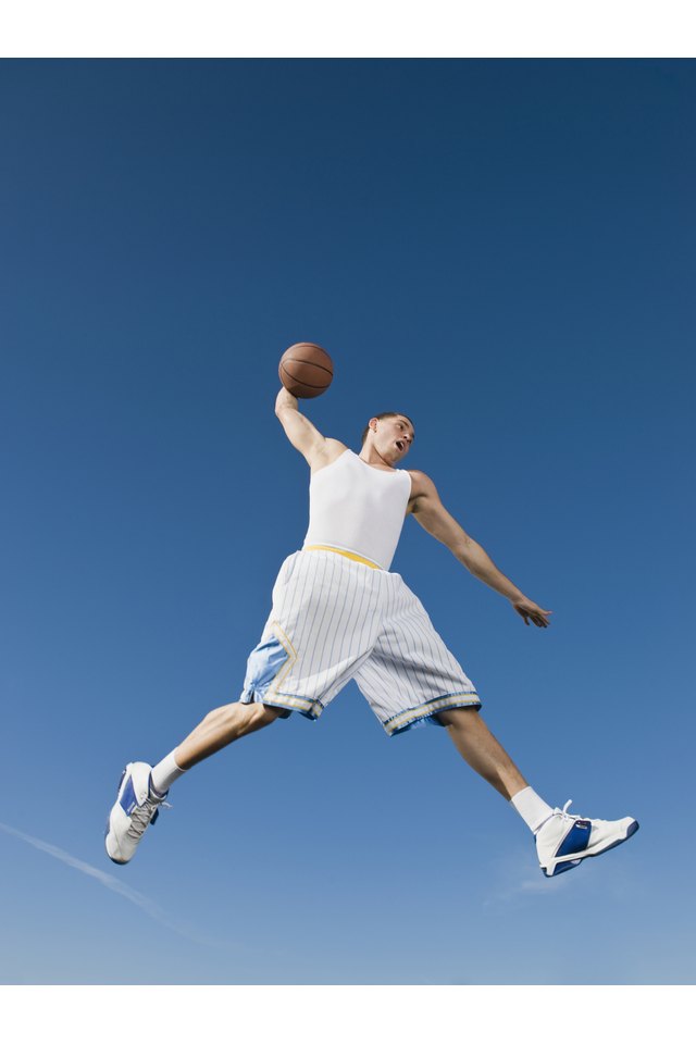 African man playing basketball in mid-air