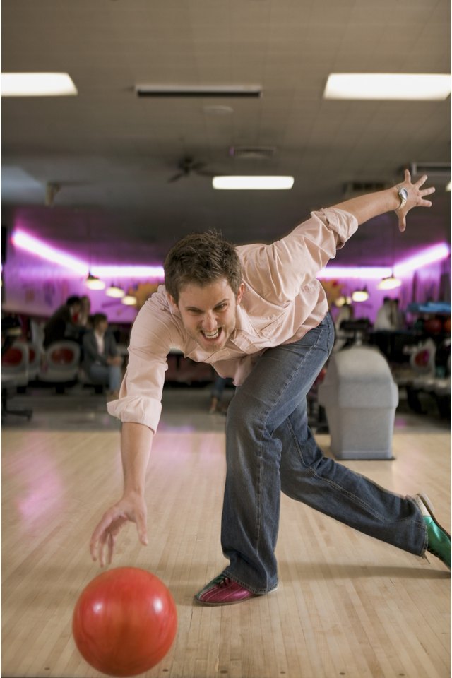 Portrait of a young man playing bowling at a bowling alley