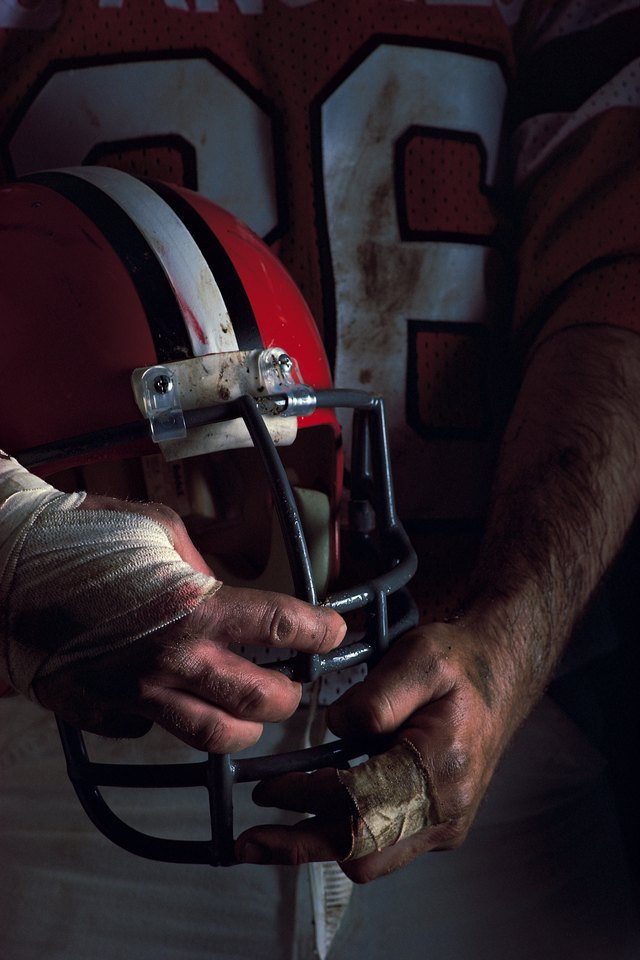 Football player holding helmet