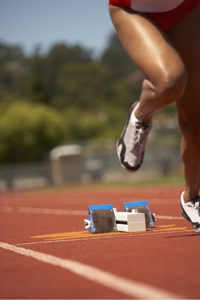 Female runner leaving starting blocks