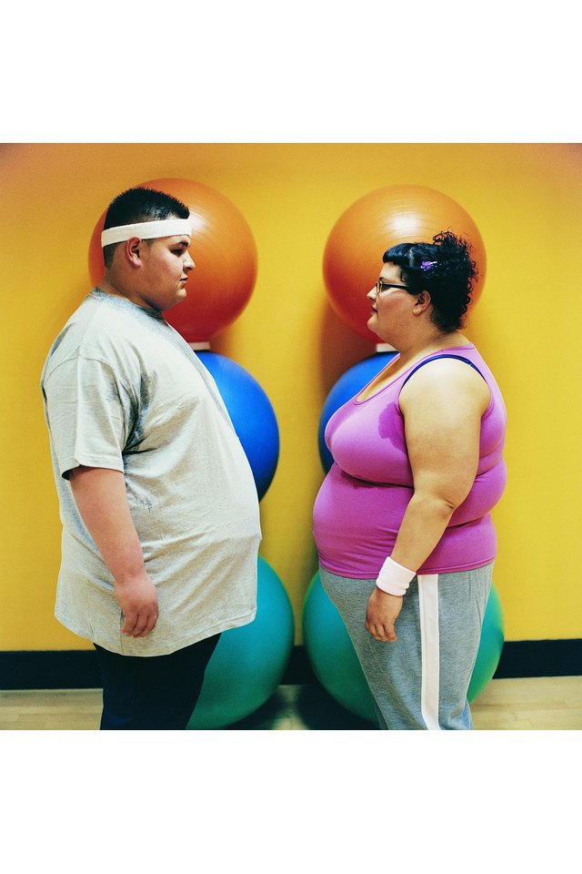 Overweight Man and Woman Standing Face to Face in a Gym