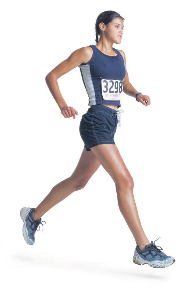 a young ethnic woman in a blue track uniform is wearing a marathon number and running