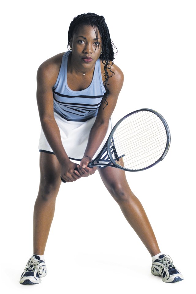young african american female tennis player in blue tank top white skirt ready to return a serve