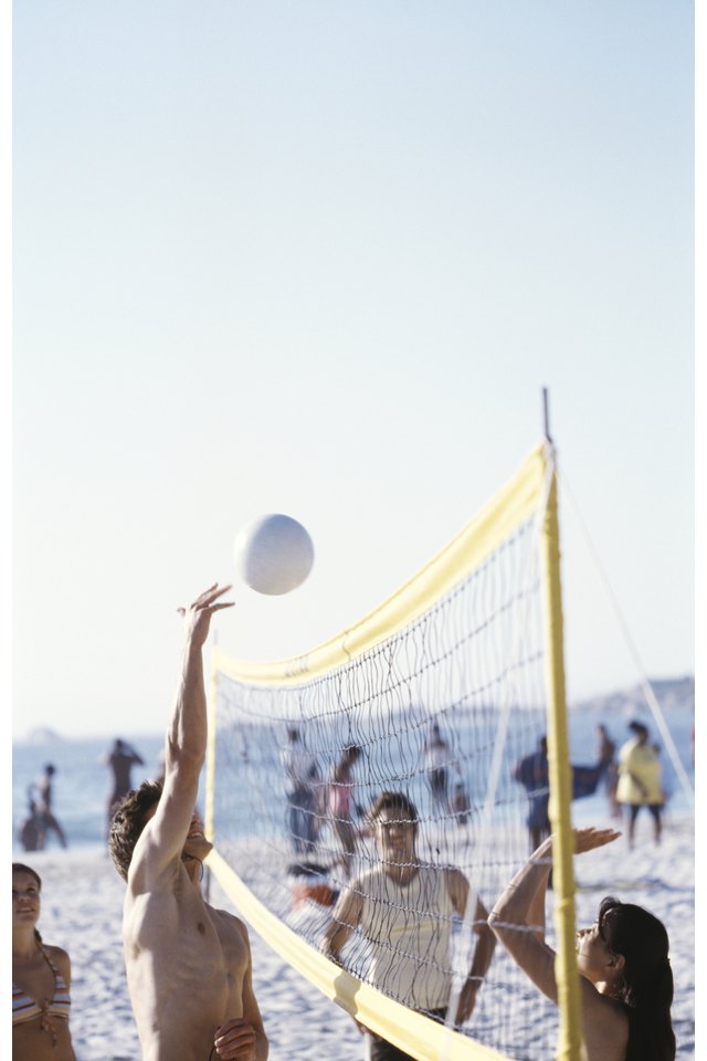 People playing beach volleyball on beach