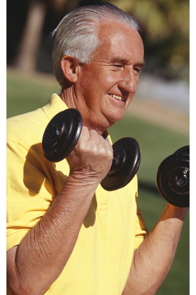 Senior man training with dumbbells, outdoors, close-up