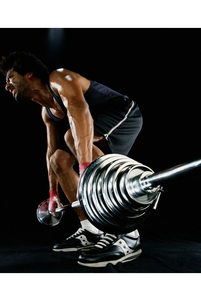 Young man lifting barbell, low angle view