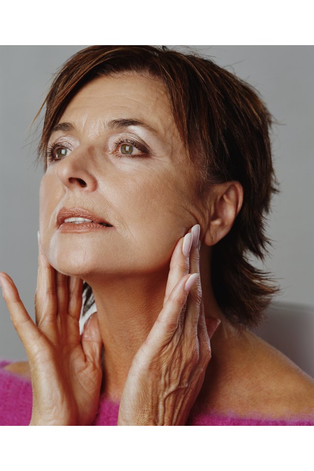 Senior woman touching jaw line with fingers, close-up