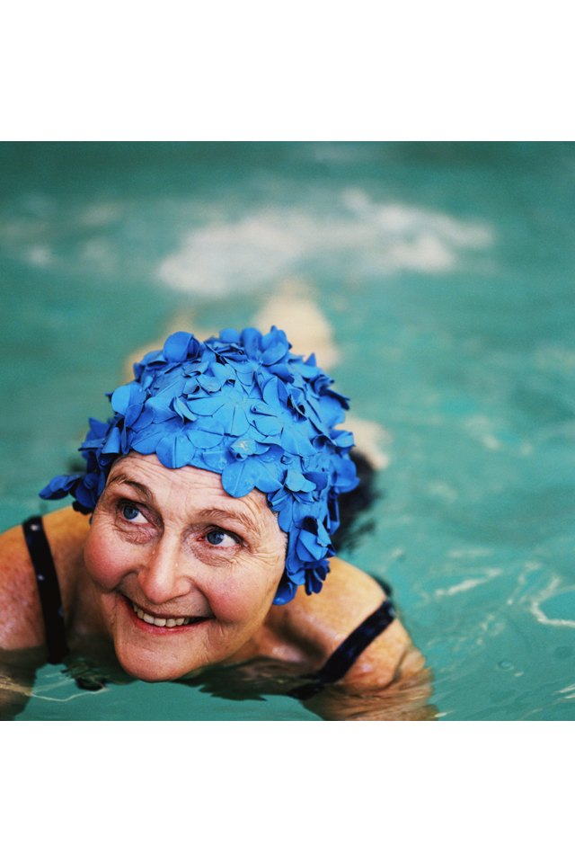 high angle view of an elderly woman in the swimming pool; smiling