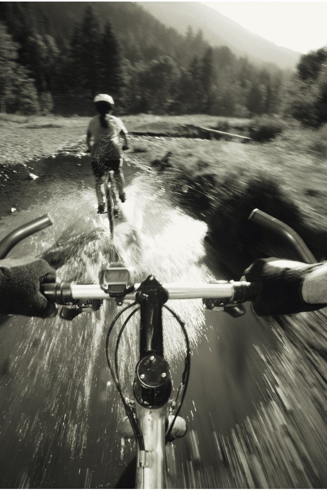 Two mountain bikers POV riding through water, Ketchum, Idaho, USA, (B&W)