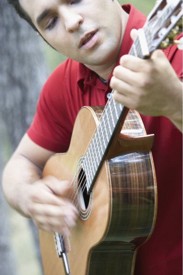 Close-up of a young man playing the guitar