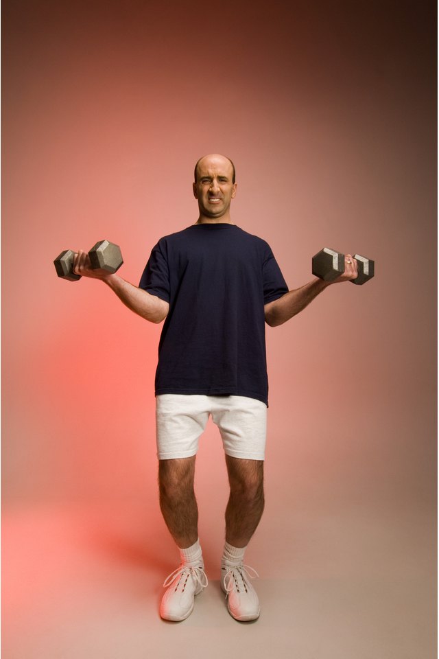 Man struggling to lift dumbbells