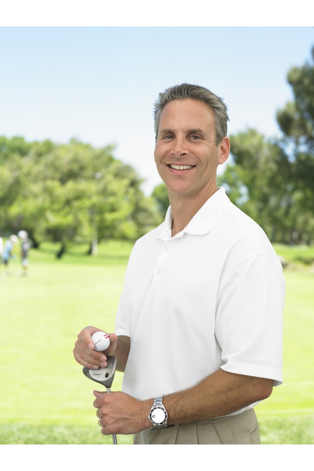 Golfer standing on golf course, portrait