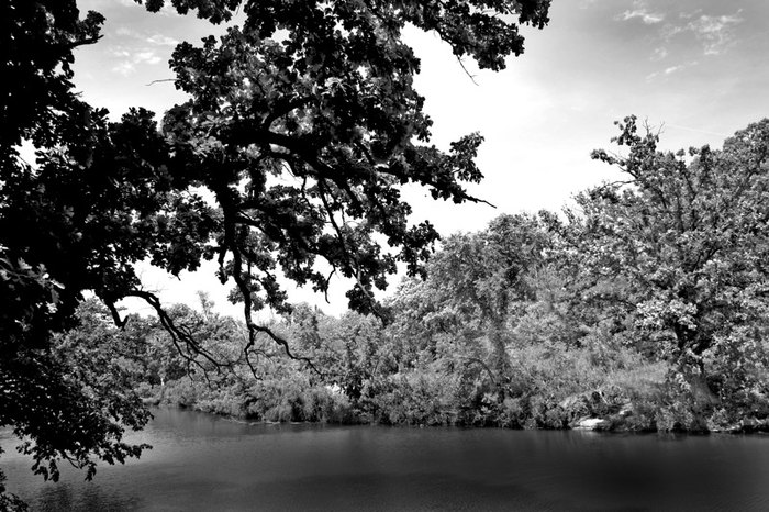 A greyscale photo of the waters near the waterfall.