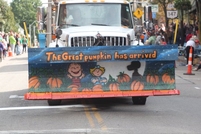 A plow truck with a picture of Charlie Brown that says "the Great pumpkin as arrived"