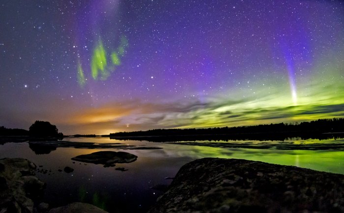 The Northern Lights glowing over the waters of Voyageurs National Park in Minnesota. The white light and wavy aurora are from the natural phenomenon known as "Steve".