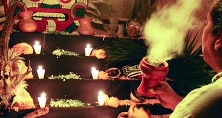 Un chamán prende incienso frente a un altar durante el Día de los Muertos.