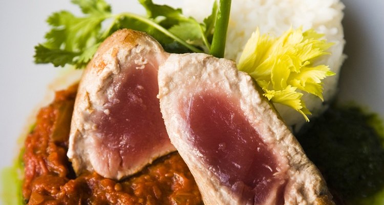 Bake tuna steaks in the oven until they begin to flake.
