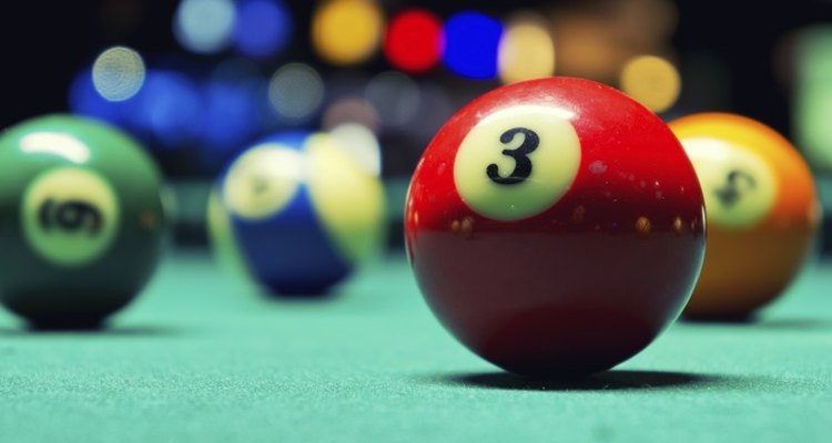 The felt of the pool table lets the ball roll smoothly.