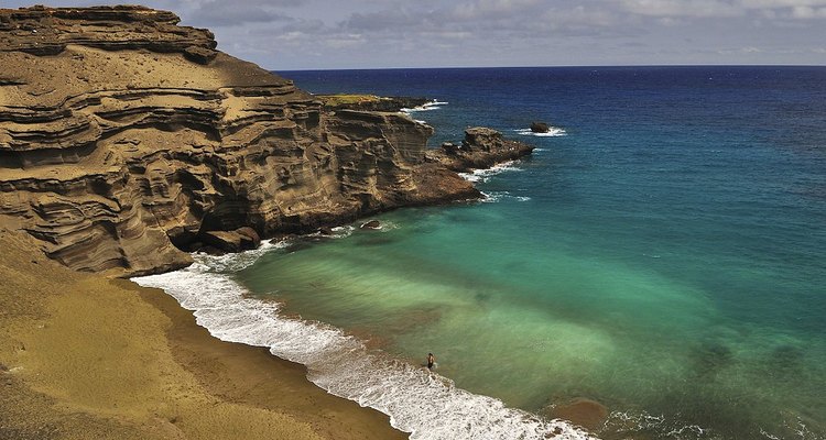 Os cristais de olivina dão uma coloração verde à areia desta praia