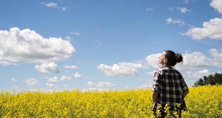 Young woman standing in a field of Canola.