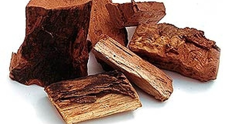 Añade pedazos de madera dura, como la del nogal, el cerezo, el manzano o alguna otra madera aromática.