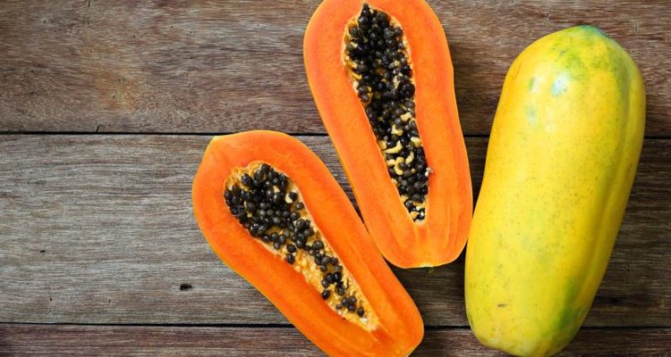 A halved papaya on a wooden table.