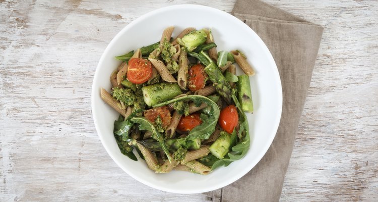 Wholemeal spelt rigatoni with green asparagus, cherry tomato and rocket pesto on plate
