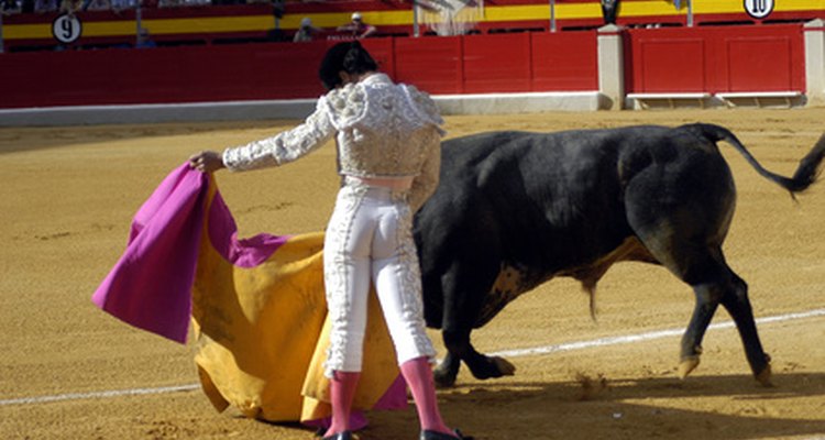 Bullfighter, wearing traditional pink socks and using a yellow-and-pink cape.