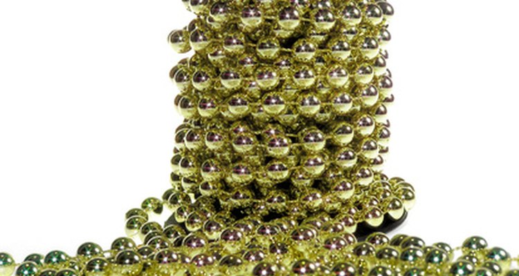 Decorate a cardboard egg with spray paints, rhinestones, gems and beads to style it in a Faberge egg design.