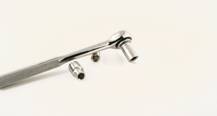 A socket wrench is used to remove the battery cable.