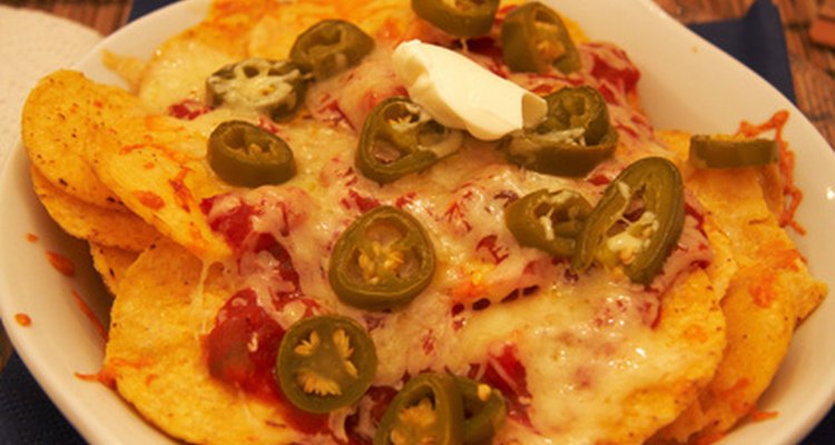 La salsa de queso vertida sobre unas frituras de tortilla crea unos deliciosos nachos.