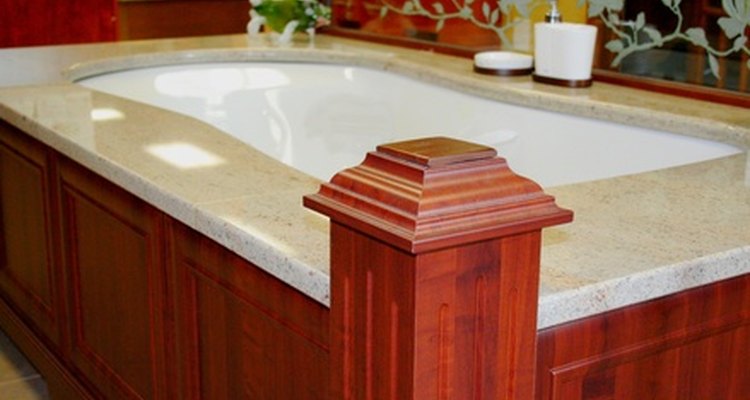 This mahogany-trimmed tub is toned down by its grey stone border.