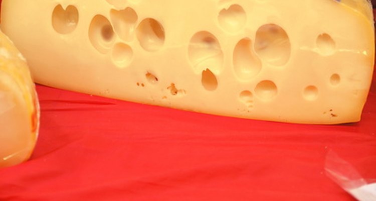 Emmental cheese tends to have round, smooth holes.