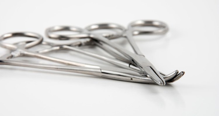 Use hemostatic forceps to assist in restringing antique composition Giggles dolls.