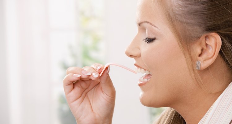 Beautiful girl taking pink chewing gum