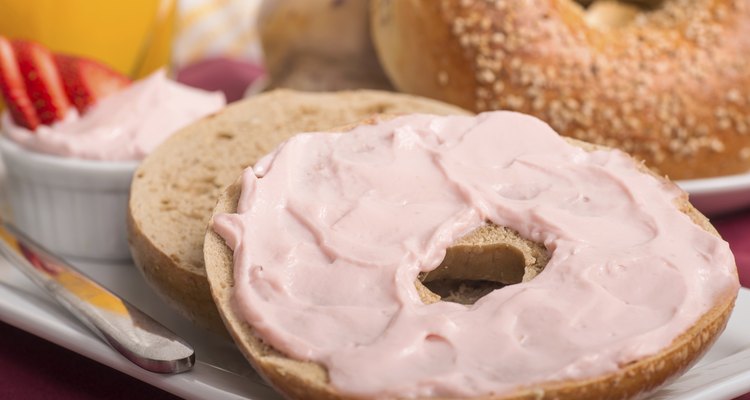 Freshly baked bagel with strawberry cream cheese, orange juice a