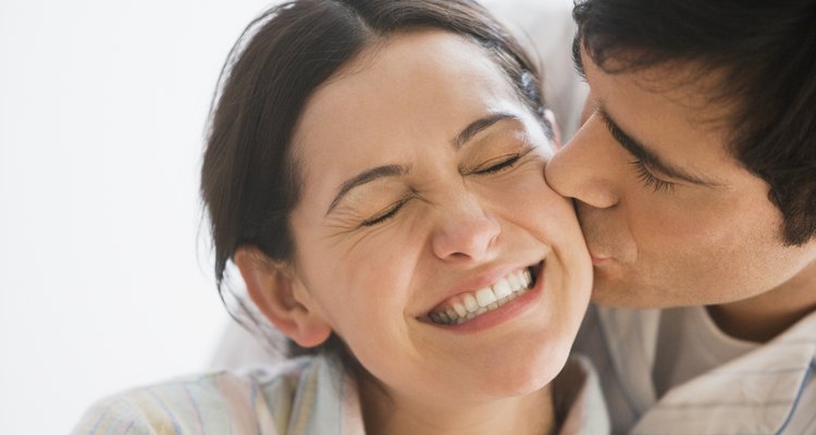 Man kissing smiling woman on cheek