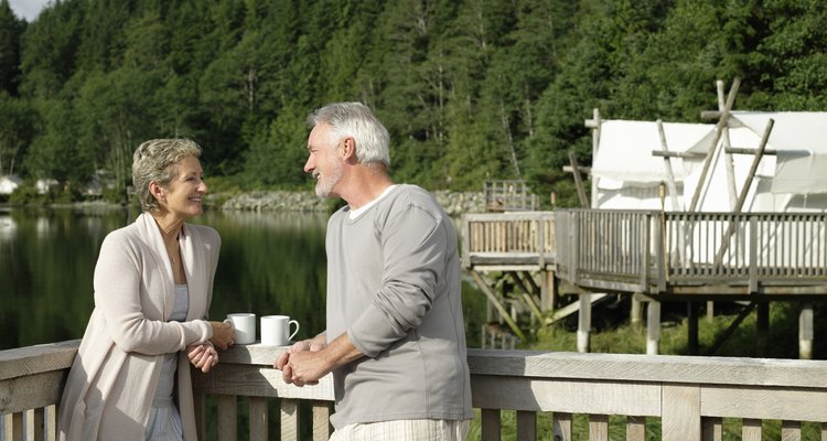 Mature couple relaxing on deck outside tent.