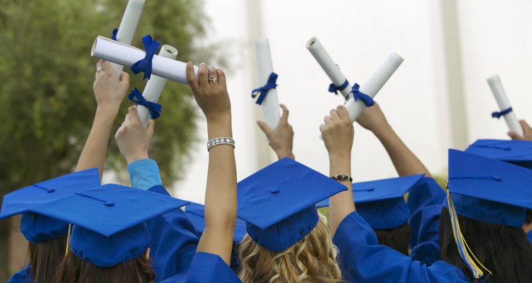 Group of Graduates Dressed in Graduation Gowns Holding Scrolls in the Air