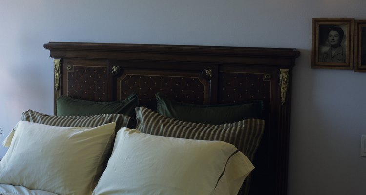 Transform a simple metal bed frame by attaching a wooden headboard.
