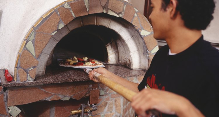 Chef putting pizza into stove