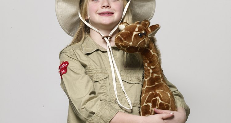 Girl (6-8) dressed as zoo keeper, holding giraffe