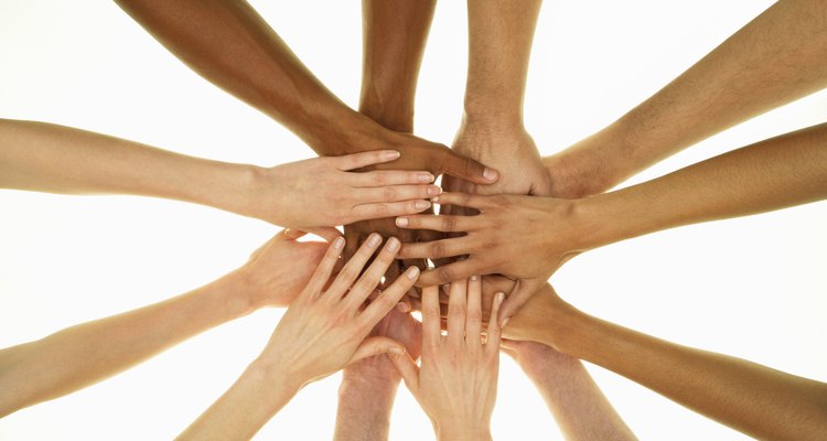 Several people stacking hands on top of each other, overhead view