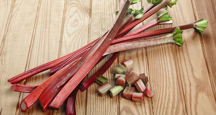 Rhubarb stalks and pieces on wooden table