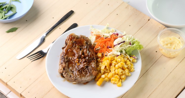 Beef Steak on white dish, plank wood background.