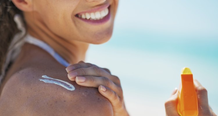 closeup on happy young woman applying sun block creme