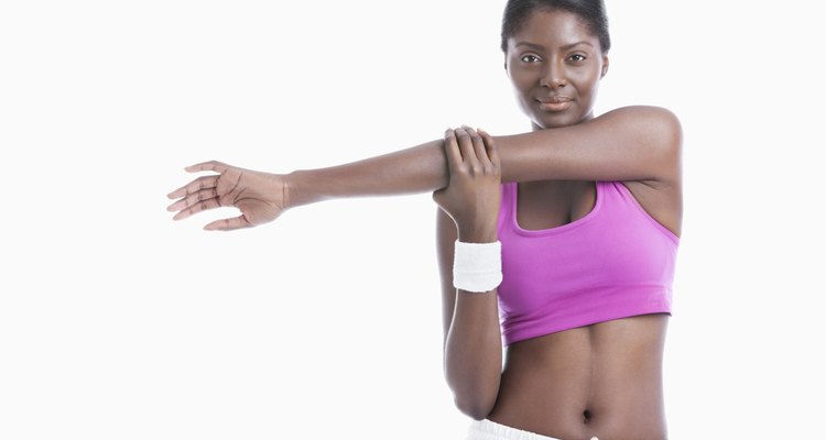 Portrait of an African American young woman stretching arm over white background